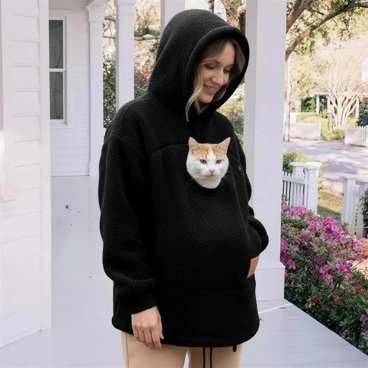 Dehors, le chat sort la tête de la poche